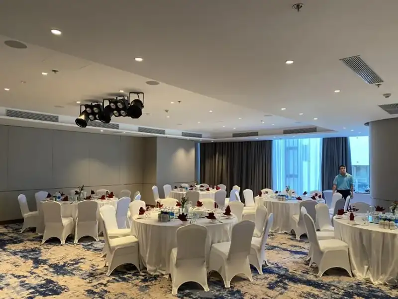 Các bàn tròn khăn trắng bày sẵn cho bữa tiệc đoàn ở Ocean Ballroom