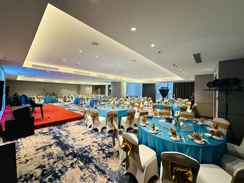 Ocean Ballroom tầng 3 bày tiệc bàn tròn khăn xanh, sân khấu trải thảm đỏ