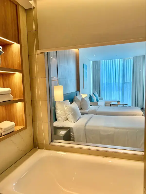 Bồn tắm nhìn qua vách kính vào phòng Executive Bay View 2 giường đơn