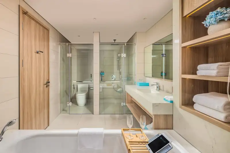 Phòng tắm hạng Premier (City View và Bay View cùng thiết kế): bồn tắm, buồng tắm đứng vách kính, bồn rửa đá
