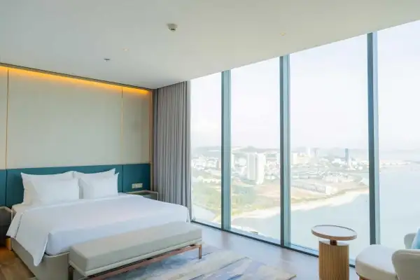 Phòng ngủ giường đôi lớn Sky Penthouse, vách kính nhìn ra vịnh và khu đô thị ven biển