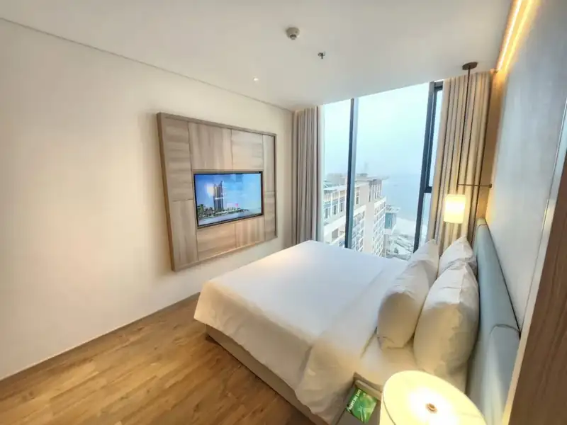 Phòng ngủ giường đôi Suite City Vista, cửa kính lớn và TV treo tường