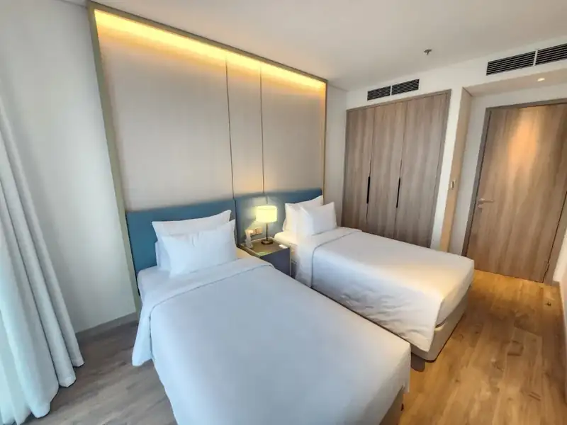 Phòng ngủ 2 giường đơn Suite City Vista, đầu giường bọc nệm xanh